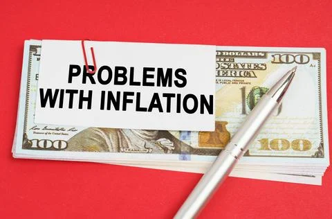 On a red surface are dollars on which a pen and paper with the inscription .. Stock Photos