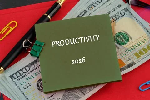 On a red surface, a notepad labeled Productivity 2026 sits on top of a stack of Stock Photos