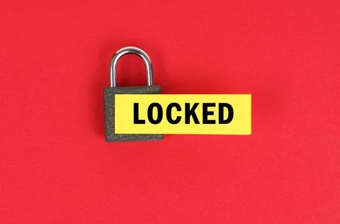 On the red surface there is a lock with a sticker with the inscription - lock 스톡 사진