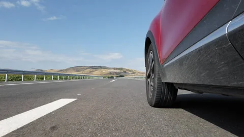 Red suv car drive fast on highway with a clear blue sky in the background, lo Stock Footage 294972329