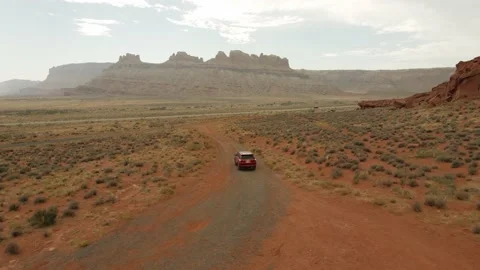 A red SUV driving off-road through the Sandy red clay of Moab, Utah Stock Footage 161078133