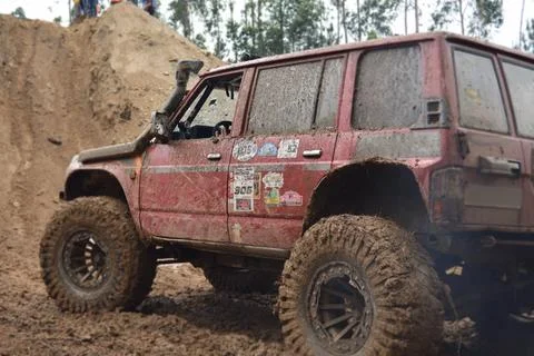 A red SUV in the mud accelerates to overcome obstacles. Foto stock