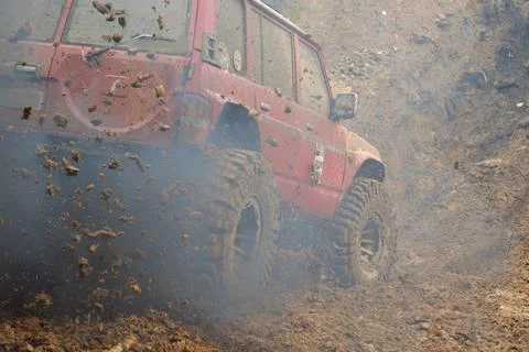 A red SUV in the mud accelerates to overcome obstacles. Off-road competition  Foto stock