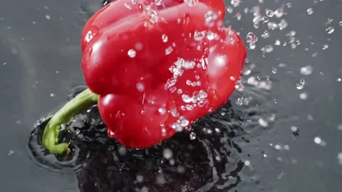 Red sweet peppers, red bellpepper, vegetable falling on water Stock Footage 147292753