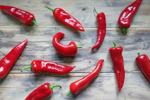 Red sweet peppers on rustic background, flat lay Stock Photos