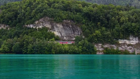 Red swiss train on bridge passing Interlaken lake Thun Brienz, Alps, Switzerland Stock Footage 123974091