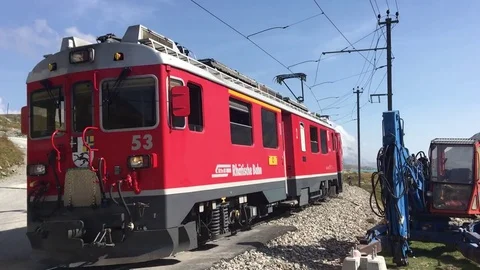 Red Swiss train passes by a rail crossing in Switzerland Stockbeeldmateriaal 81355105
