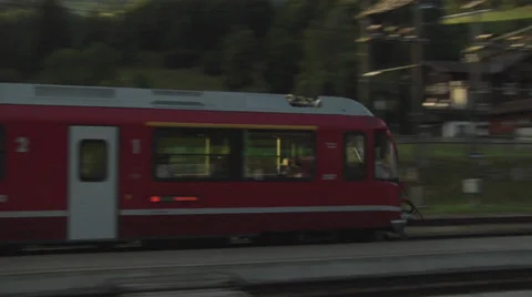 Red Swiss train pulls into the railway station in Küblis, Switzerland Stock Footage 31823570