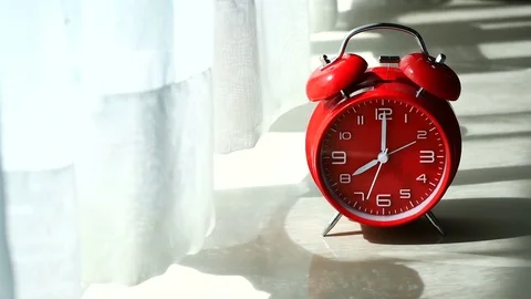 Red table clock in the weekend mornning at window with curtains and Vertical  Stock Footage 76912001