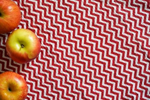 Red table cloth zigzag texture with apples Foto stock
