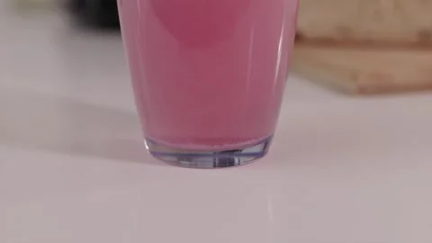 Red tablet dissolving on the bottom of glass and rising up Stock Footage 332724622