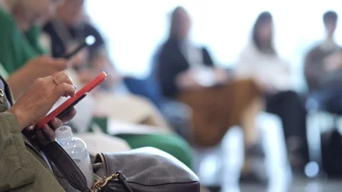 Red tablet in foreground, people in background waiting Stock Footage 341456733