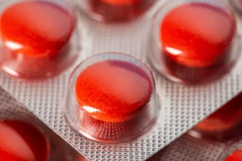 Red tablets in a blister, macro. Concept of sedative tablets and sleeping pills Stockfoto's