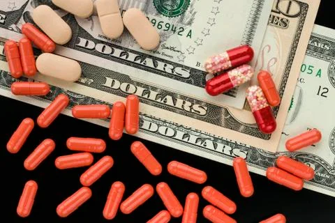 Red tablets, capsules on dollars background Stock Photos