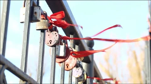 Red tapes tied to the fence develop in the wind, locks hang on the fence Stock Footage 135238101