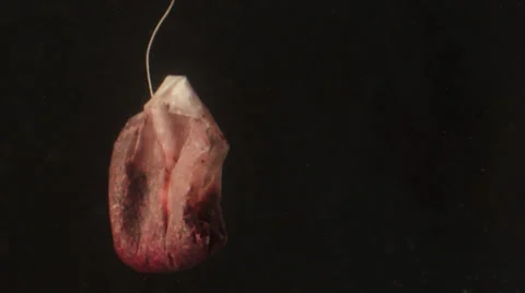 A red tea bag in water Stock Footage 24899024