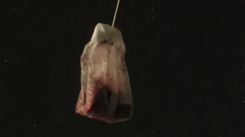 A red tea bag in water Stock Footage 24899282
