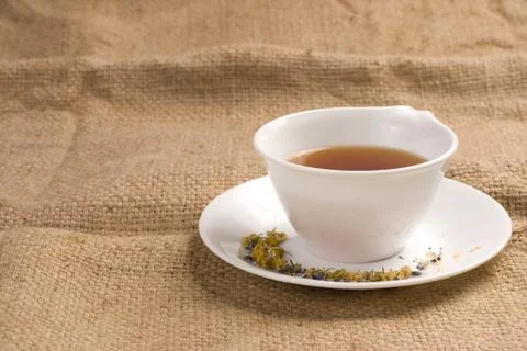 Red tea in ceramic cup with burlap background Stock Photos