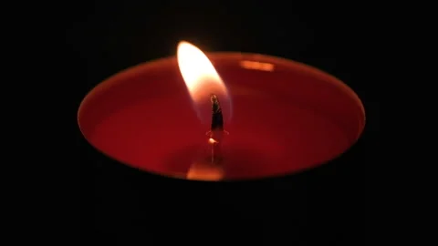 Red tealight candle flame slowly flickering and burning out in complete darkness Stock Footage 343424750