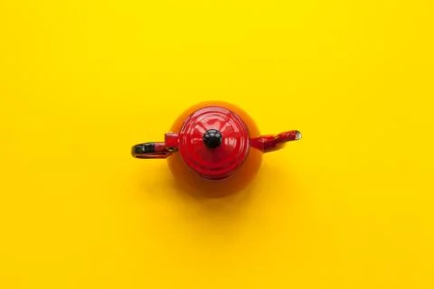 Red teapot on solid yellow background Stock Photos