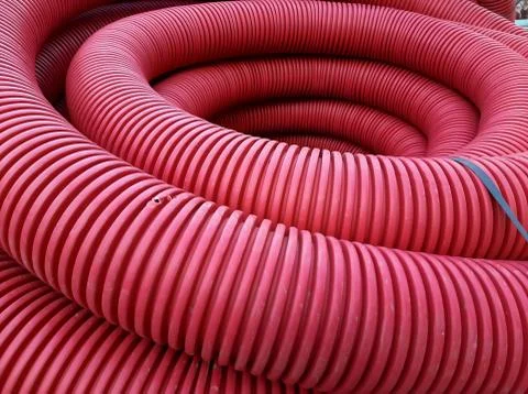 Red telecommunication corrugated cable casing pipe 库存照片