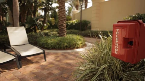 Red Telephone Box Next to Row of Pool Chairs Video stock 102573113