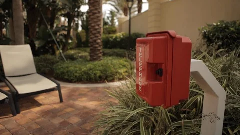 Red Telephone Box Next to Row of Pool Chairs Stock Footage 102573334