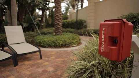 Red Telephone Box Next to Row of Pool Chairs Stock Footage 102573700