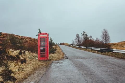 Red telephone box on a side of a road in the Scottish Highlands Foto stock