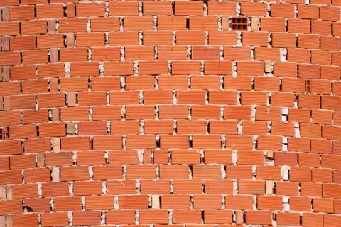 Red terracotta bricks forming a robust wall texture, showcasing durable con.. Stock Photos