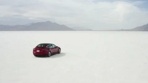 Red Tesla Model 3 drifting in Bonneville Salt Flats Stock Footage 132592120