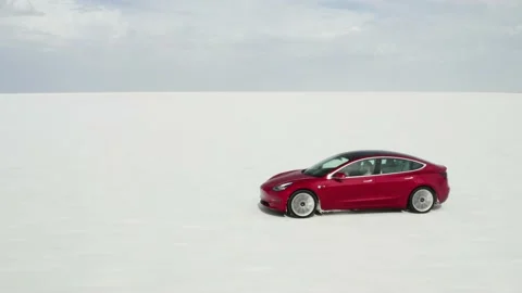 Red Tesla Model 3 drifting in Bonneville Salt Flats Stock Footage 132592139