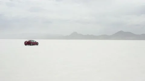 Red Tesla Model 3 drifting in Bonneville Salt Flats Stock Footage 132592186