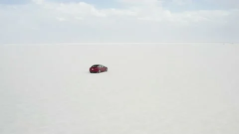 Red Tesla Model 3 drifting in Bonneville Salt Flats Stock Footage 132592188
