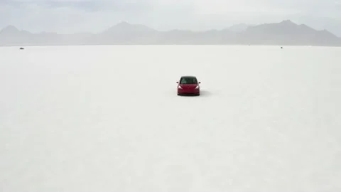 Red Tesla Model 3 drifting in Bonneville Salt Flats Stock Footage 132592189