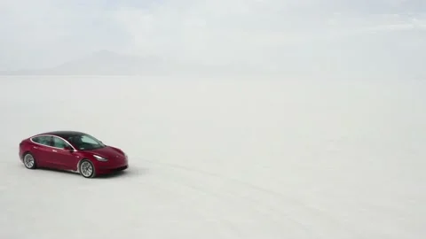 Red Tesla Model 3 drifting in Bonneville Salt Flats Stock Footage 132592194