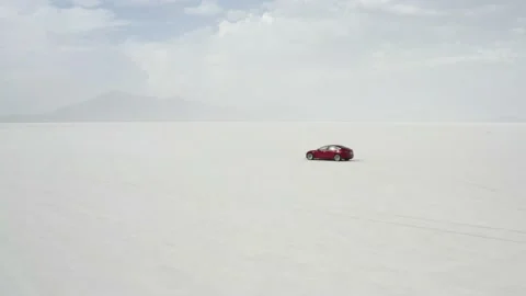 Red Tesla Model 3 drifting in Bonneville Salt Flats Stock Footage 132592216