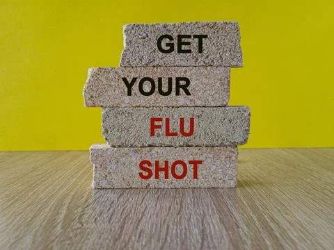 Red text GET YOUR FLU SHOT written on brick blocks. Stock Photos