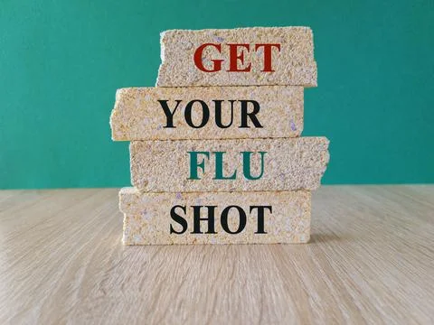 Red text GET YOUR FLU SHOT written on brick blocks. Stock Photos