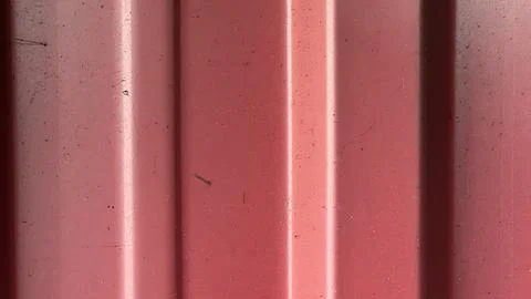 Red texture with vertical lines and subtle imperfections in sunlight Stock Photos