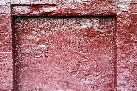 Red textured wall surface with old peeling paint and rough masonry structure 写真素材
