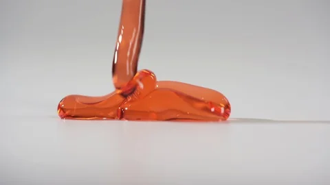 Red thick liquid flowing down on the flatness on white background. 2x slowmotion Stock Footage 123986495