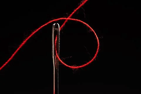 Red thread and needle on black background Stock Photos