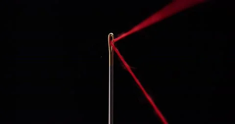 Red thread going through needle eye, closeup Stock-Footage 168364065