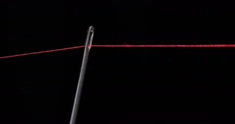 Red thread going through needle eye, closeup Stock Footage 168364122