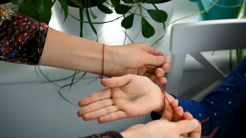 Red thread on hand. Selective focus. Stock Footage 224110068