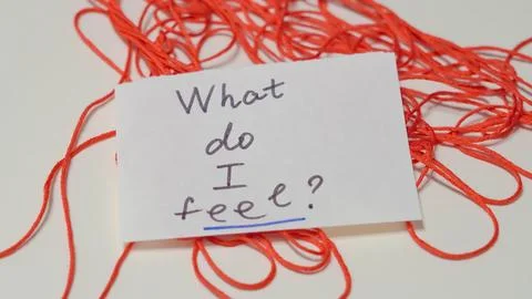 Red thread with handwritten note asking "What do I feel?" Stock Photos