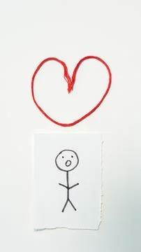 Red thread heart above hand-drawn stick figure on white background Stock Photos
