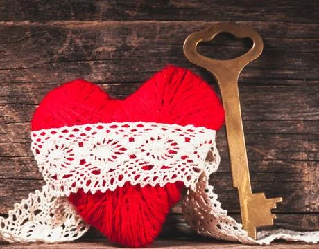 Red thread heart Red thread heart and golden key over wooden background Co... Stock Photos