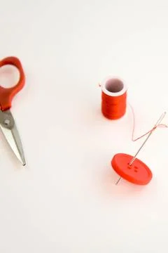 Red thread, needle, button and scissors Stock Photos